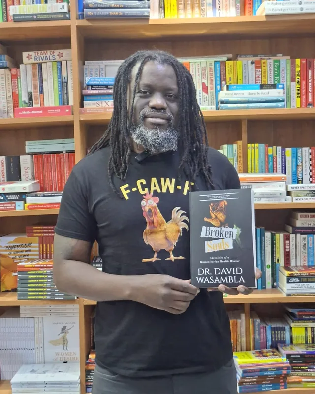 Dr. David Wasambla holding a copy of Broken Souls in a Nairobi bookshop.