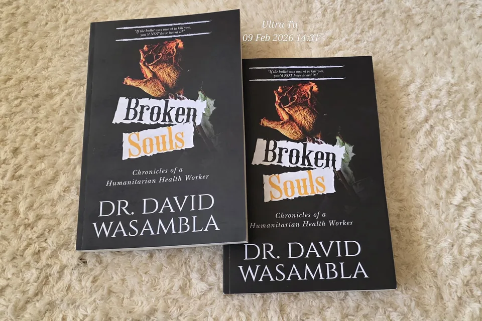 Two paperback copies of Broken Souls: Chronicles of a Humanitarian Health Worker by Dr. David Wasambla.
